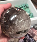 Smoky Quartz Sphere with Black Tourmaline Inclusions and a massive Rainbow Flash– 85mm